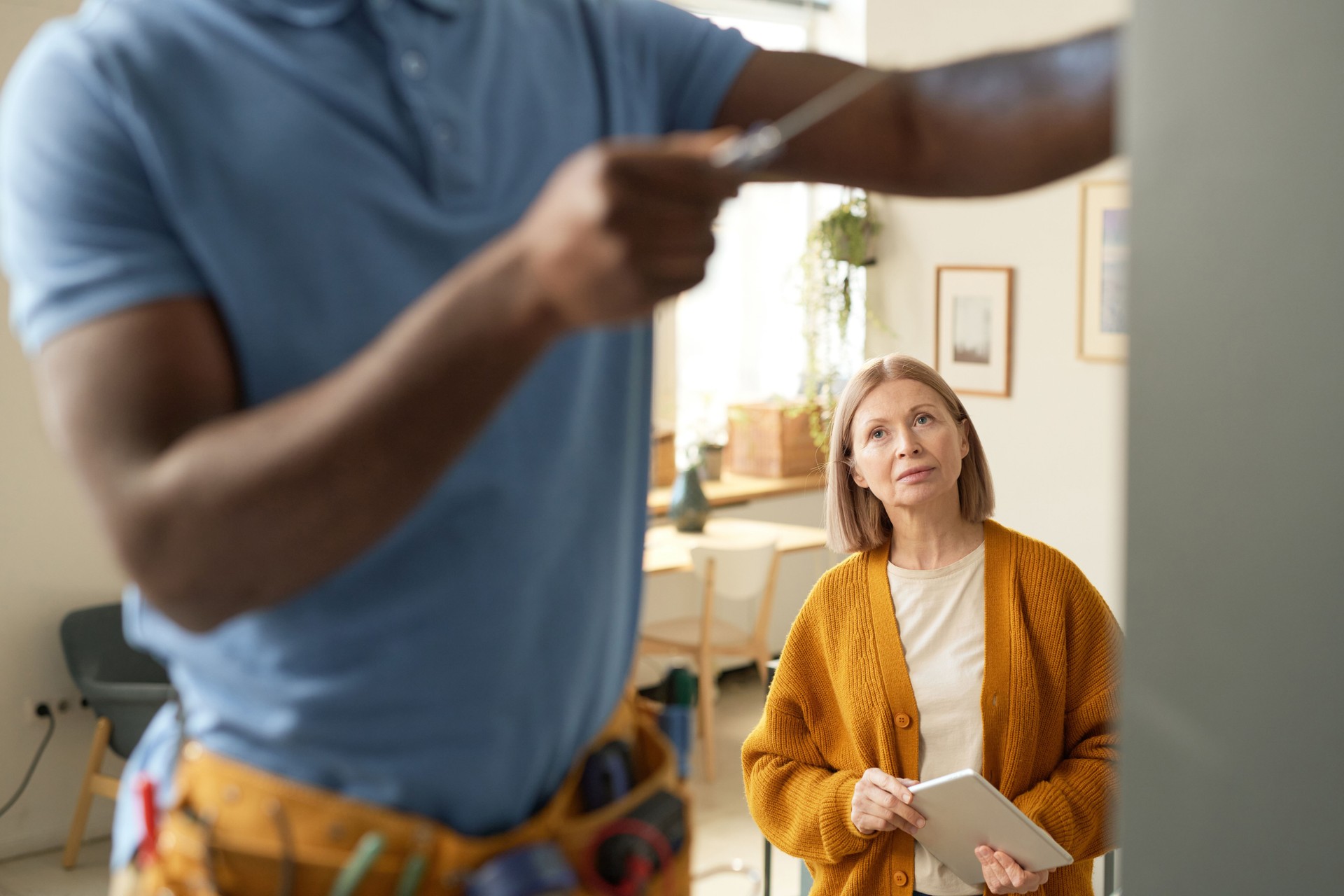 Blonde Senior Woman Watching Man Doing Home Repairs